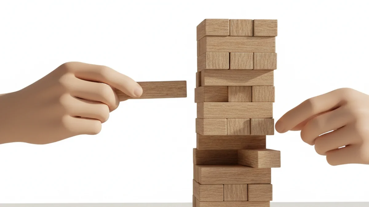 Mãos retirando um bloco de madeira de uma torre instável prestes a cair.