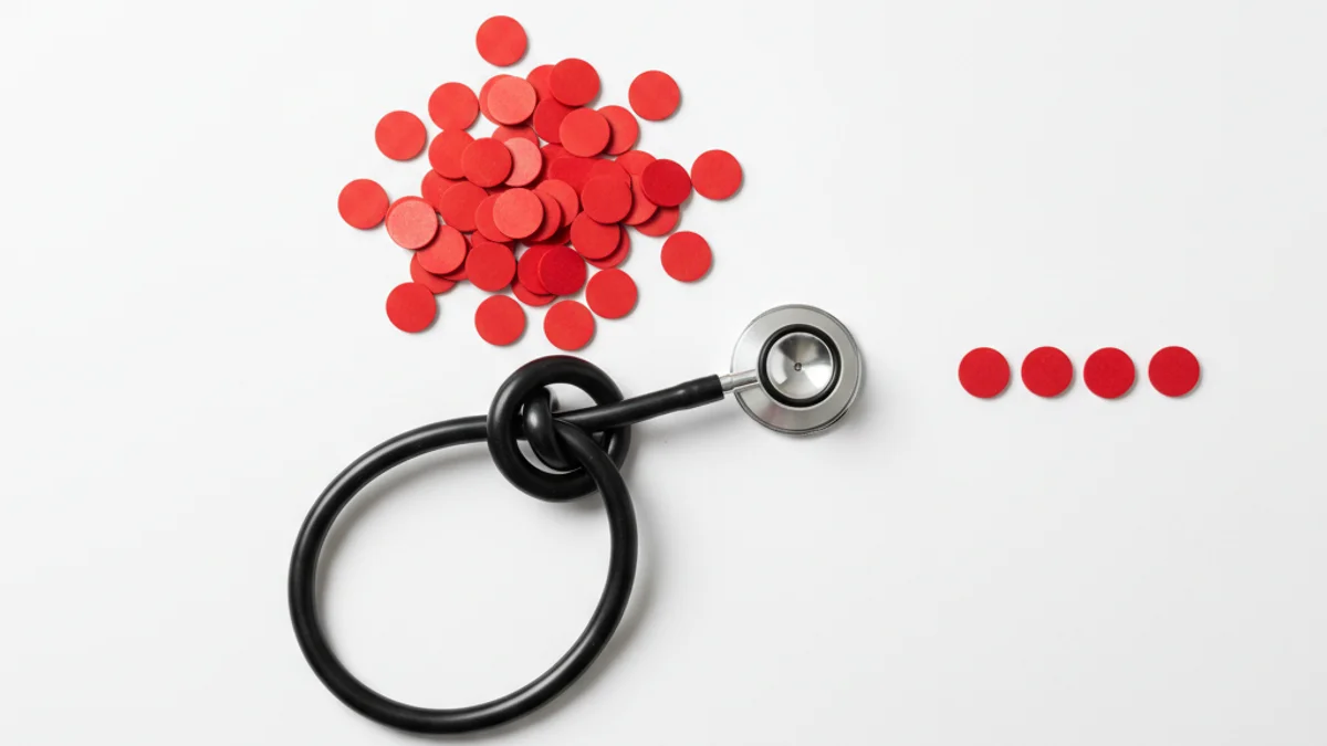 Estetoscópio com tubo em nó sobre superfície clínica branca com marcadores vermelhos espalhados.
