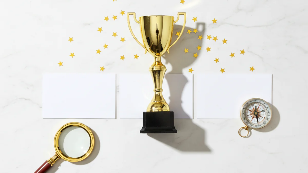 Três cartões de visita competindo pelo troféu central com estrelas e lupa ao redor.