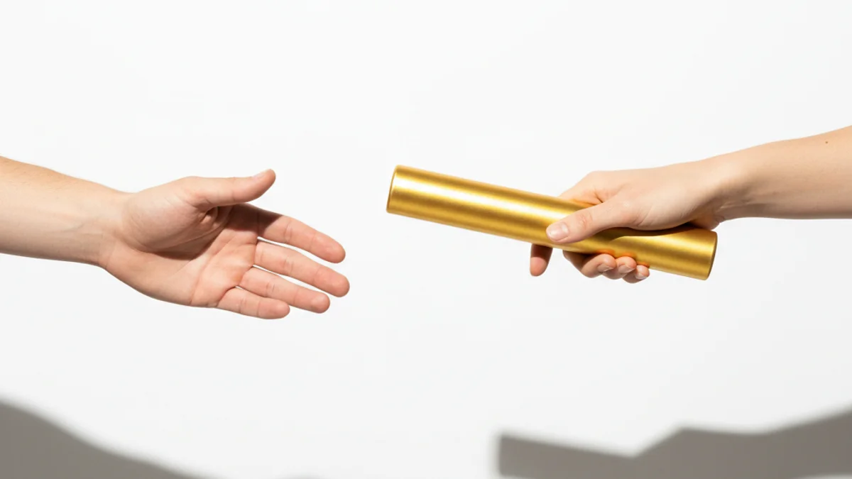 Mãos passando bastão dourado de revezamento com borrão de movimento transmitindo urgência.